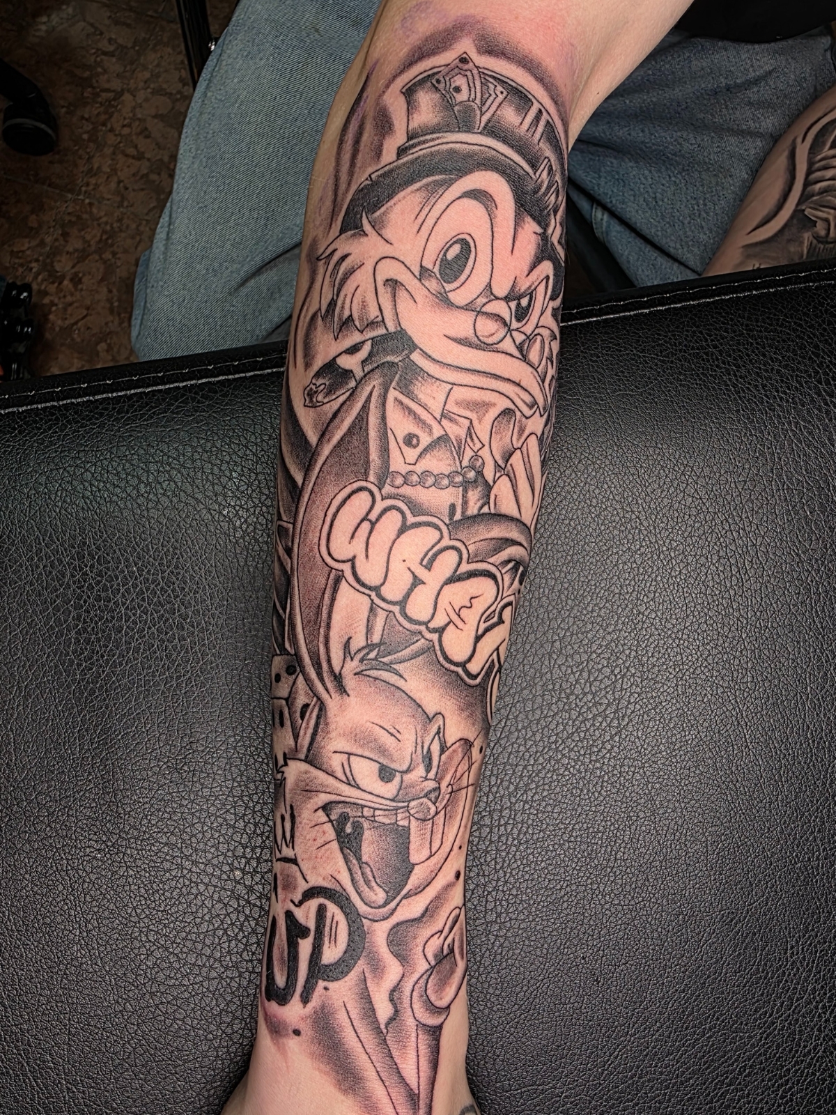 Comic Tattoo – Dagobert Duck und Bugs Bunny, selbstsicher und verschmitzt, buntes Armtattoo – Saints Tattoo Pirna